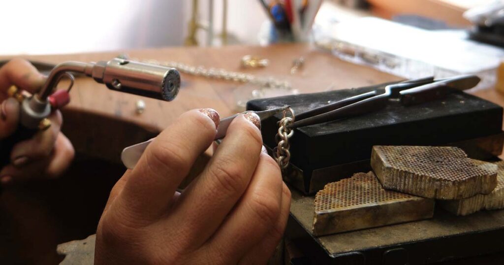 hombre trabajando haciendo manualidades en casa con joyeria y bisuteria